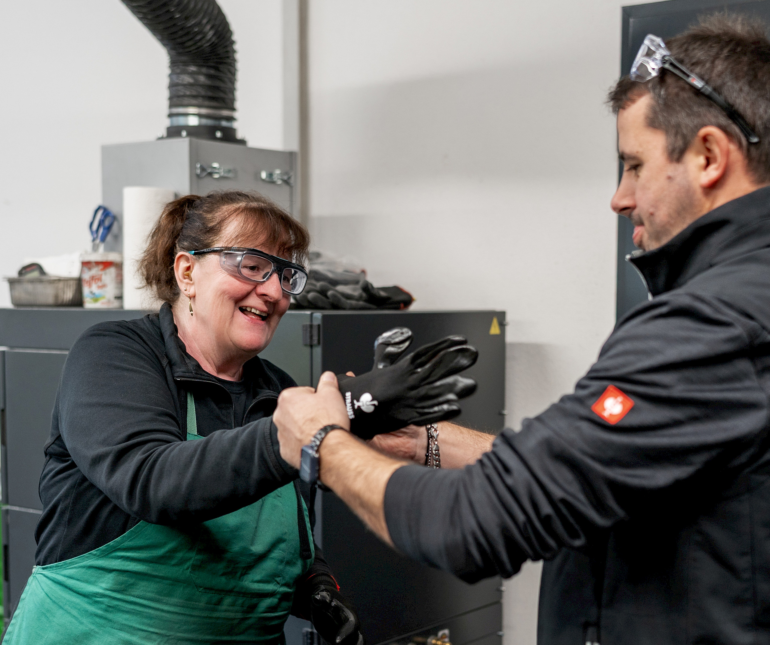 Ein Mann hilft einer Dame in den Handschuh. Hilfsbereitschaft und Teamwork sind uns wichtig.