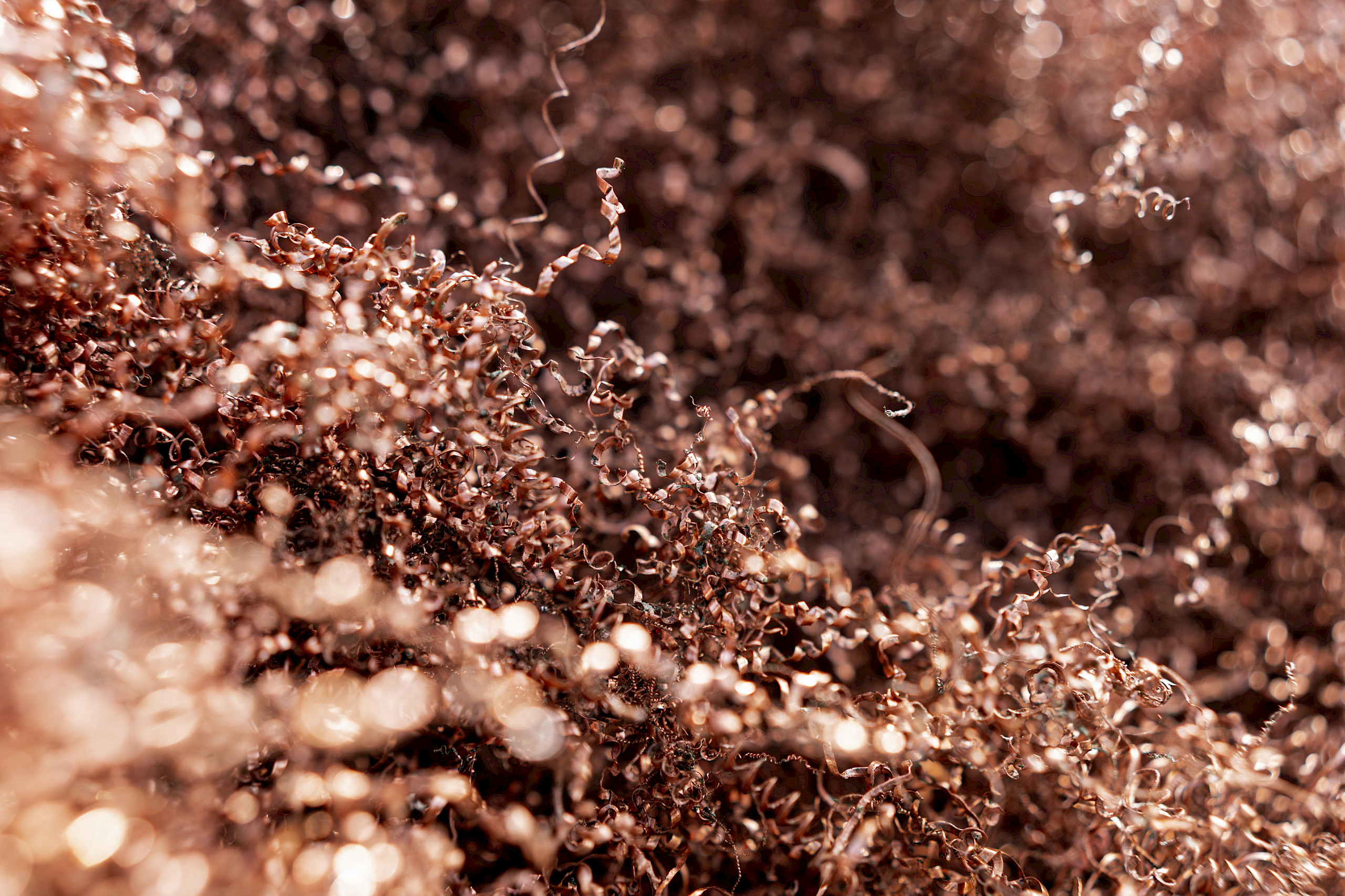 Nahaufnahme von Metallspänen in hellem Licht mit einer Vielzahl von verdrehten und gekrümmten Formen.