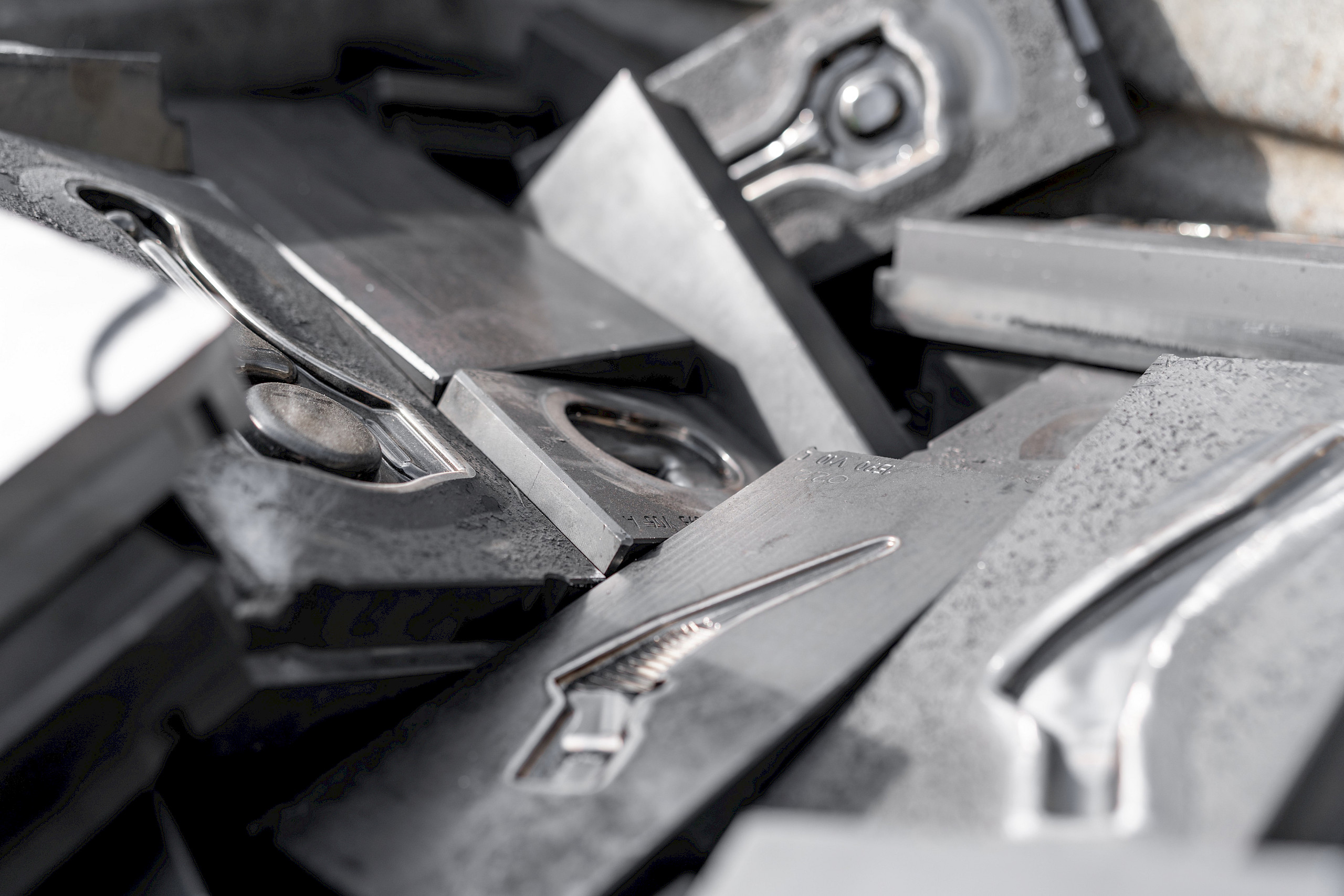 Haufen von Metallstücken aus HSS-Werkzeugstahl, teilweise mit geprägten Formen.